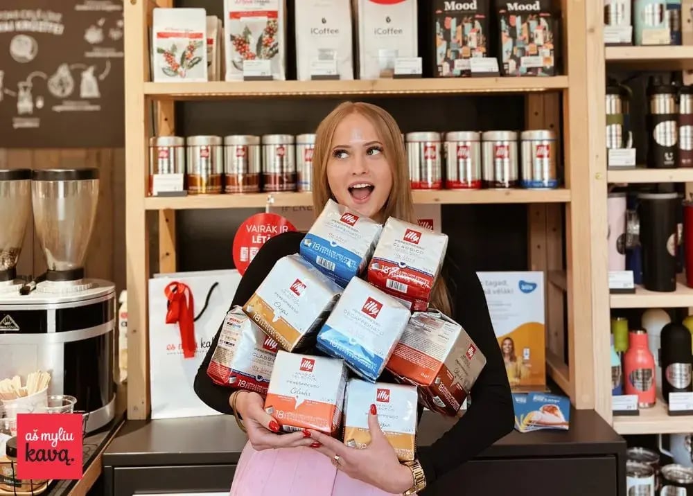 Woman holding coffee in the Aš Myliu Kavą store