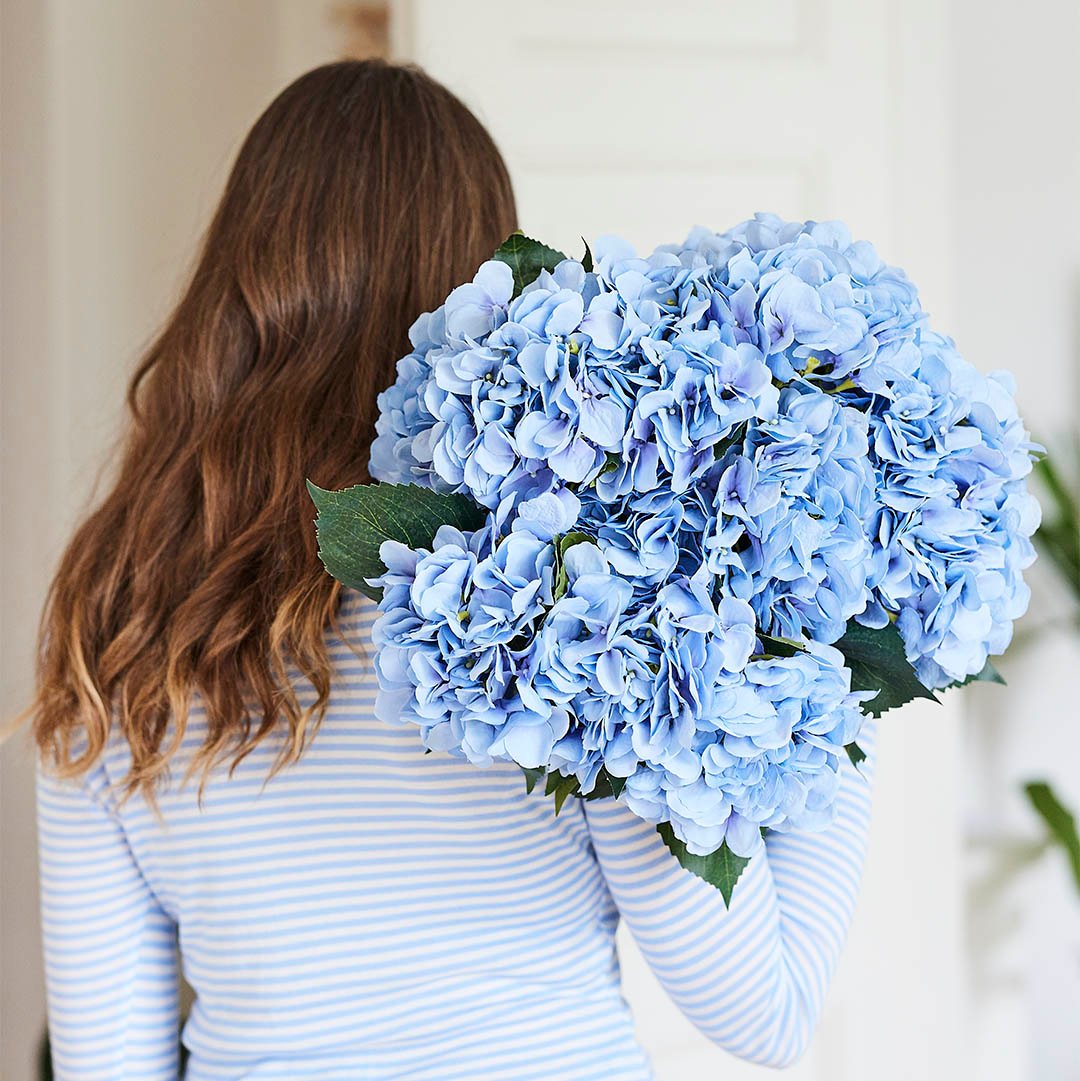 Woman holding a bouquet of light blue flowers