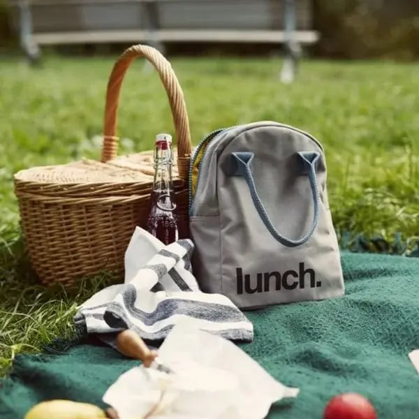 Picnic basket, quilt and rucksack in the park