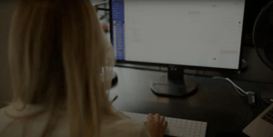 A blonde woman working at a computer
