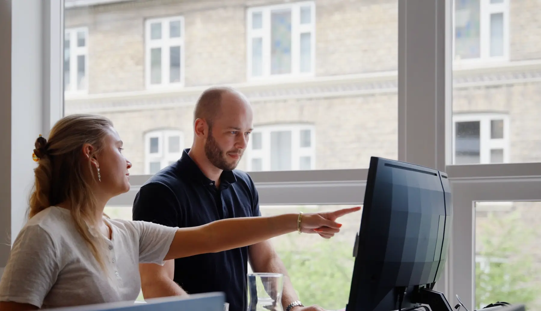 Two employees working at a computer