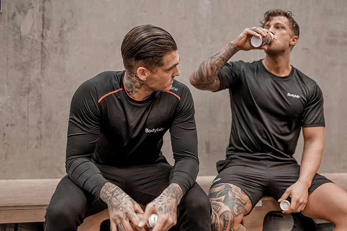 Two guys working out and drinking Bodylab products